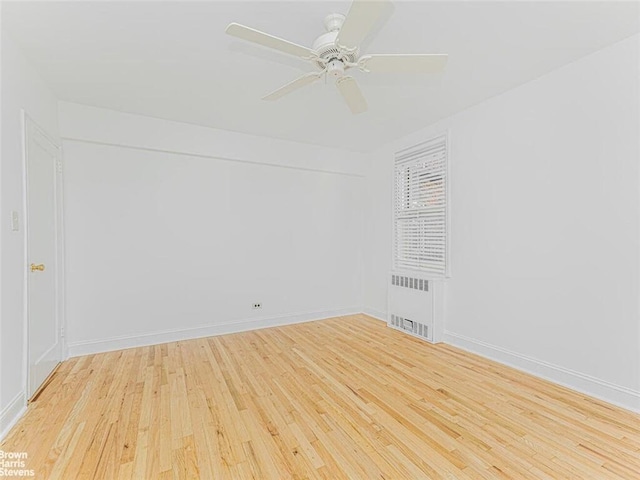 empty room with radiator, ceiling fan, and light hardwood / wood-style floors