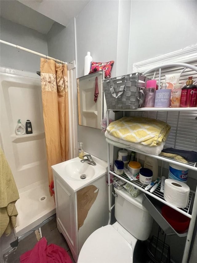 bathroom featuring vanity, toilet, and walk in shower