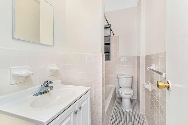 full bathroom with vanity, shower / tub combination, tile walls, tile patterned flooring, and toilet