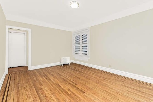 empty room featuring hardwood / wood-style flooring and radiator