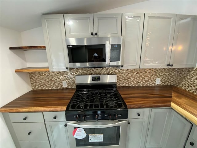 kitchen with gray cabinets, decorative backsplash, wooden counters, and stainless steel appliances