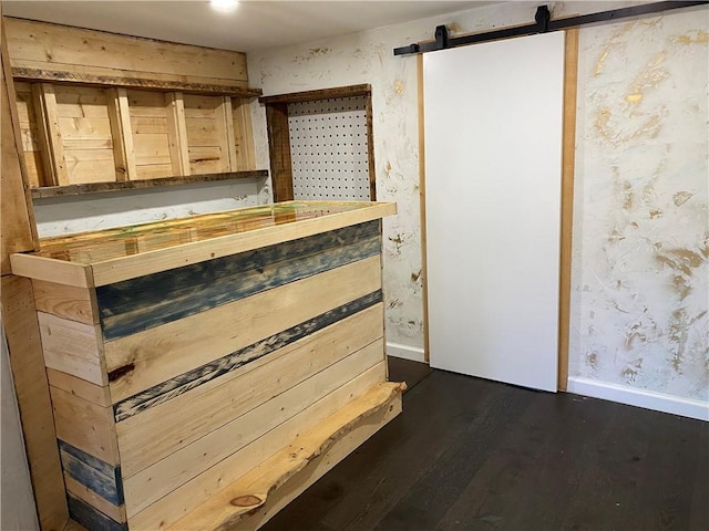 bar featuring dark hardwood / wood-style floors and a barn door