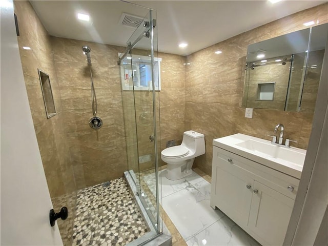 bathroom featuring walk in shower, vanity, tile walls, and toilet