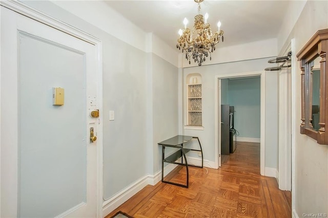 corridor featuring parquet flooring and a notable chandelier