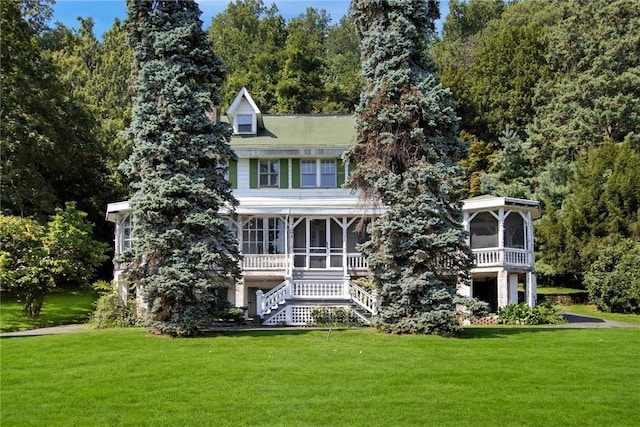 back of property featuring a lawn and a sunroom