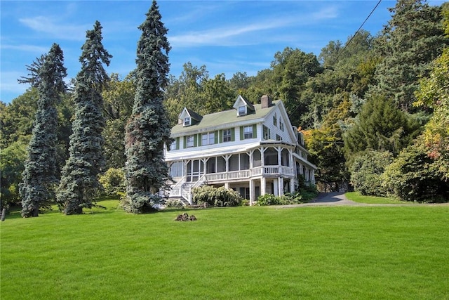 view of front of property featuring a sunroom and a front yard