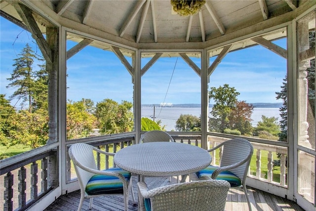 sunroom with a water view and vaulted ceiling