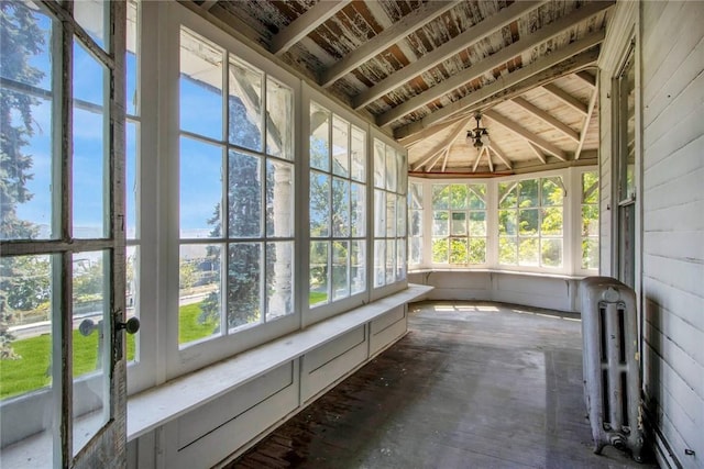 unfurnished sunroom with radiator heating unit and vaulted ceiling