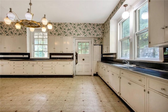 kitchen with a chandelier, sink, and pendant lighting