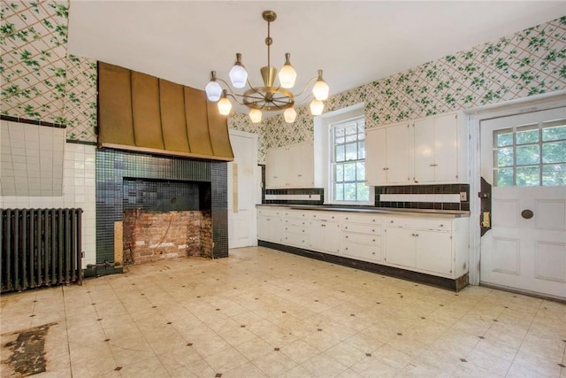 kitchen with white cabinetry, radiator heating unit, pendant lighting, and an inviting chandelier