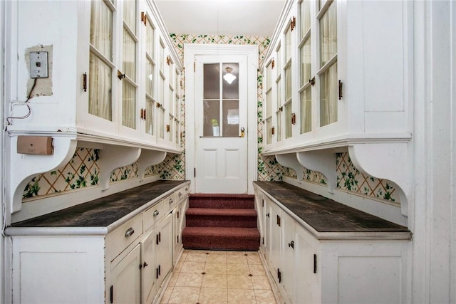 bar with white cabinets and light tile patterned floors