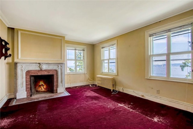 unfurnished room with a wealth of natural light, radiator heating unit, carpet, and crown molding