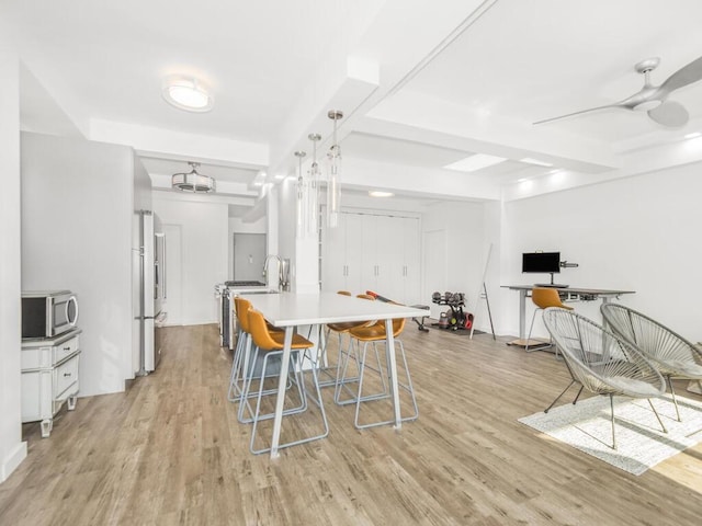 dining room with ceiling fan and light wood-type flooring