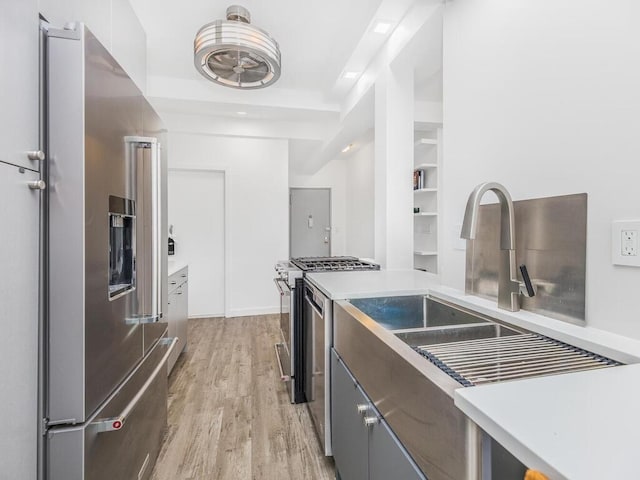 kitchen featuring light hardwood / wood-style flooring, white cabinets, stainless steel appliances, and sink