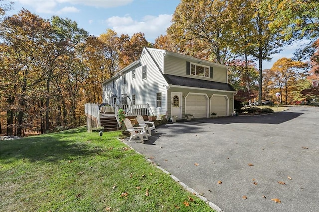 view of property exterior with a garage, a yard, and a deck