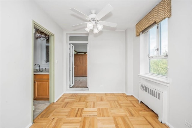 interior space with radiator heating unit, light parquet floors, and sink