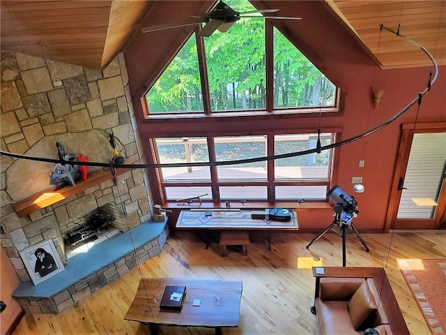 unfurnished living room with high vaulted ceiling, wooden ceiling, a wealth of natural light, and light hardwood / wood-style flooring