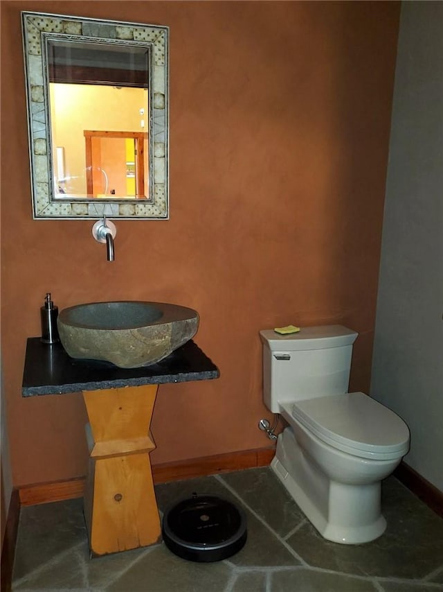 bathroom featuring tile patterned flooring, toilet, and sink