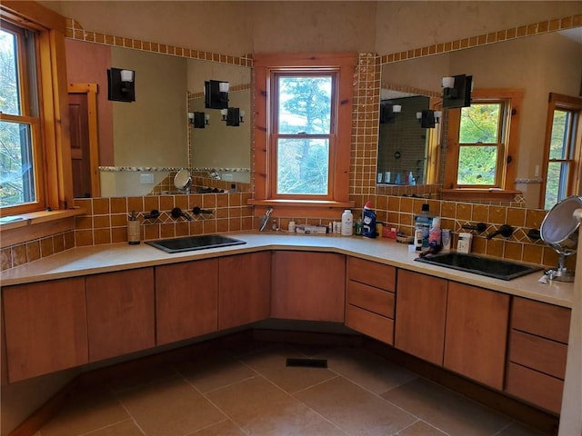 kitchen with light tile patterned flooring, tasteful backsplash, and sink