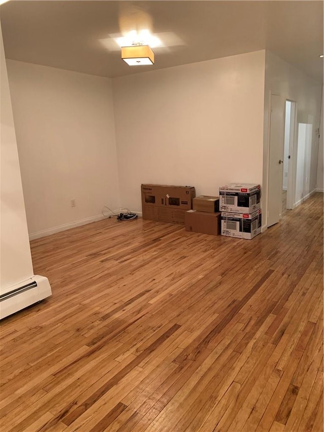 unfurnished room with light hardwood / wood-style floors and baseboard heating