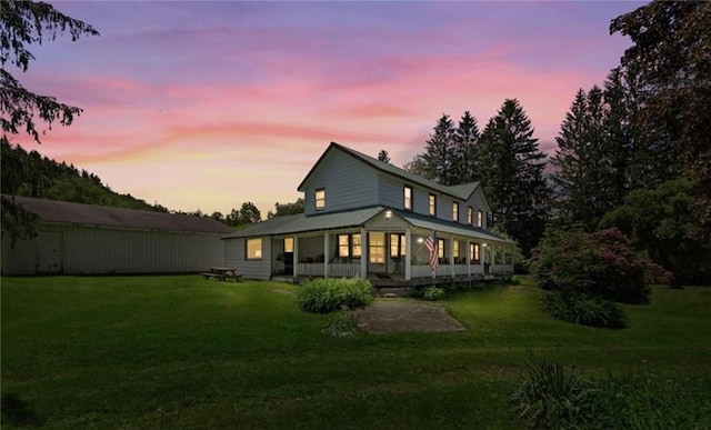 back house at dusk with a lawn