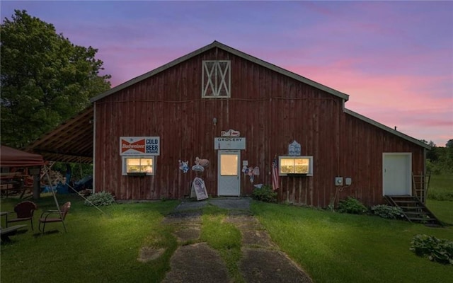 outdoor structure at dusk featuring a lawn