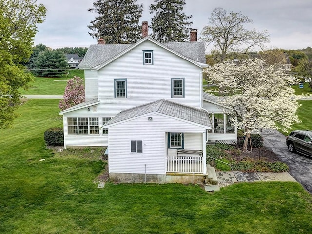 rear view of property with a yard and a porch