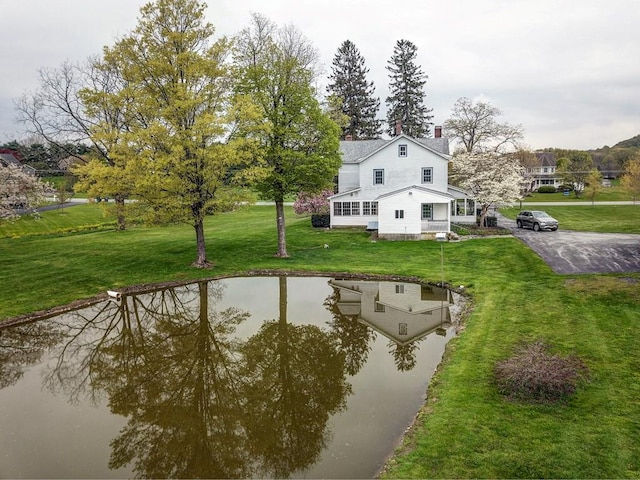 exterior space featuring a lawn and a water view