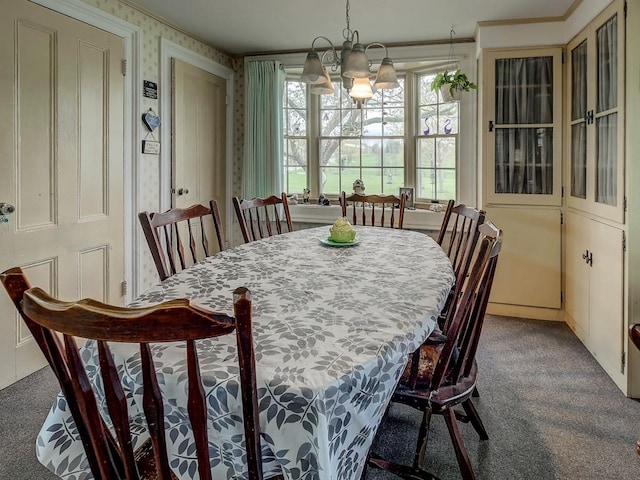 carpeted dining area featuring an inviting chandelier