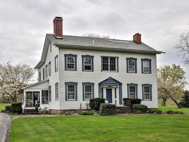 colonial house with a sunroom and a front yard