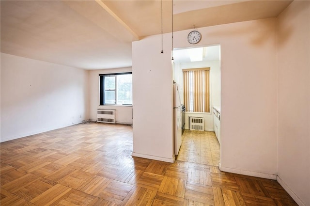 empty room with radiator and light parquet flooring