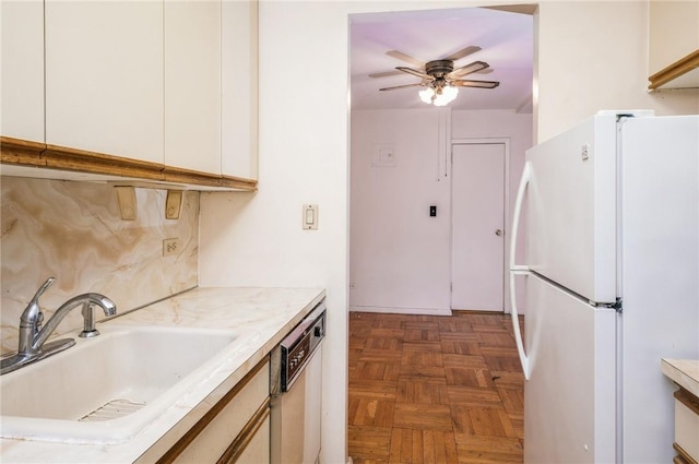 kitchen featuring dark parquet flooring, white cabinets, white refrigerator, sink, and stainless steel dishwasher