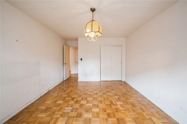 interior space with light parquet floors and a notable chandelier