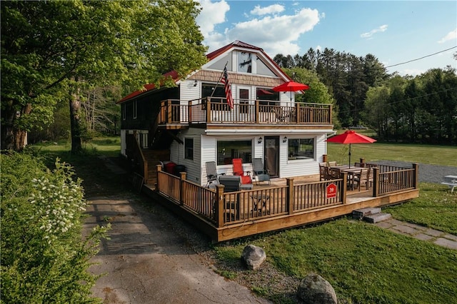 rear view of house with a lawn and a wooden deck