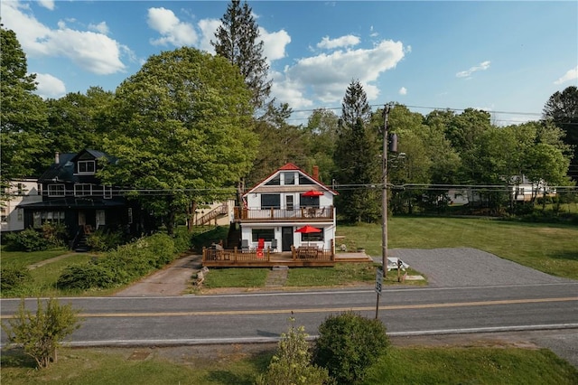 view of front facade featuring covered porch, a balcony, and a front yard