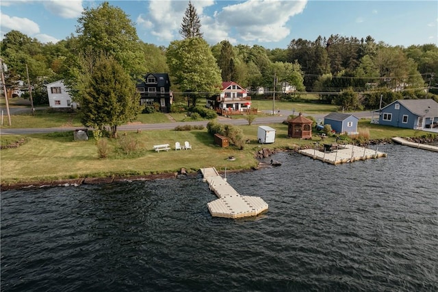 surrounding community with a water view and a storage shed