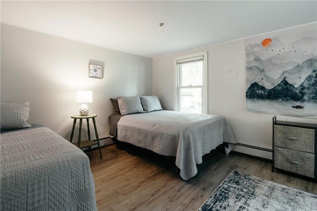 bedroom with baseboard heating and dark hardwood / wood-style floors