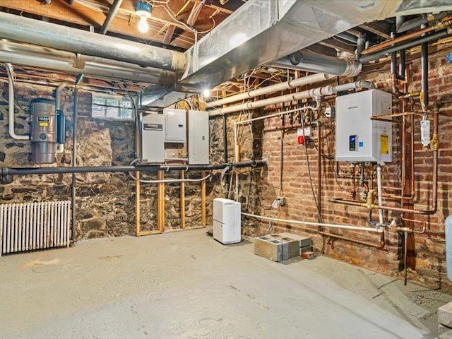 2 Pine Hill Rd, Chester, NY 10918 - unfinished below grade area with radiator heating unit, electric panel, and tankless water heater