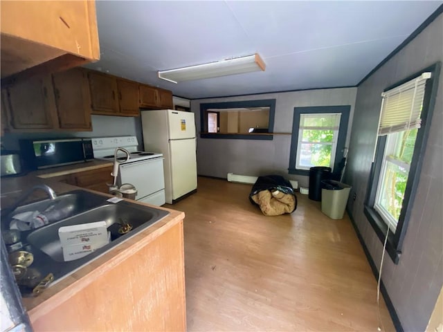 kitchen with light wood-type flooring, white appliances, sink, and a baseboard heating unit