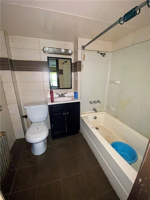 full bathroom featuring vanity, bathtub / shower combination, tile patterned floors, toilet, and tile walls