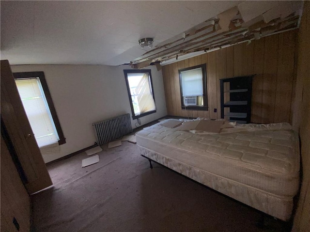 unfurnished bedroom with wood walls, lofted ceiling, radiator, cooling unit, and carpet floors