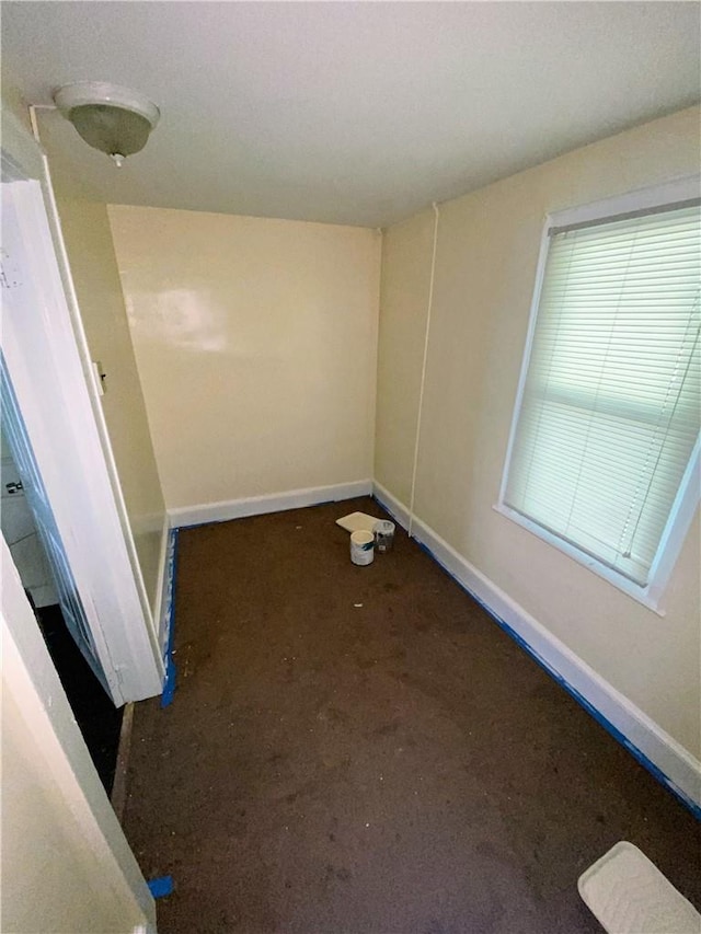 unfurnished room featuring dark carpet