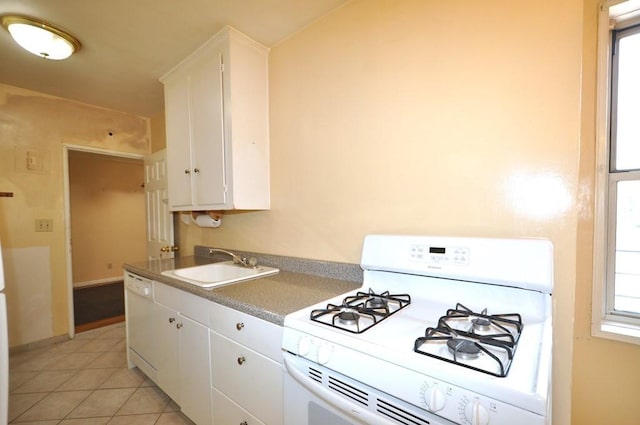 kitchen featuring white cabinetry, sink, light tile patterned floors, and white appliances