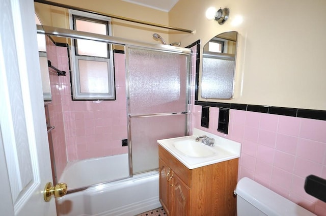 full bathroom featuring vanity, toilet, tile walls, and enclosed tub / shower combo