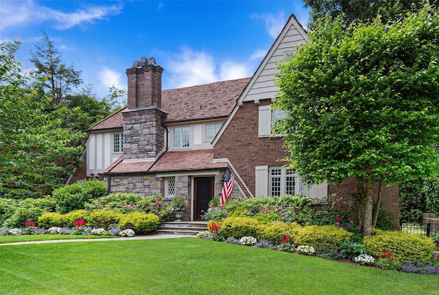 tudor home featuring a front lawn