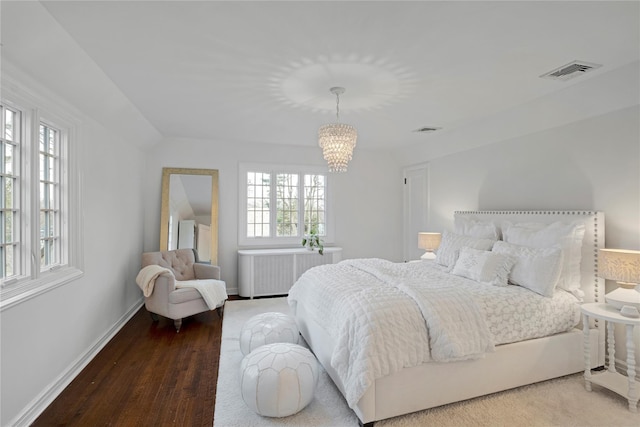 bedroom featuring hardwood / wood-style flooring and a notable chandelier