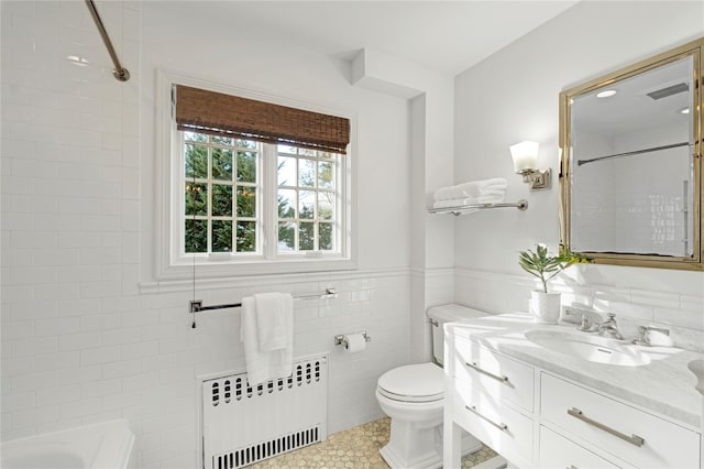 bathroom with toilet, tile walls, a tile shower, radiator heating unit, and vanity