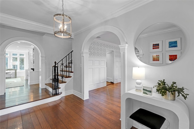 foyer with ornamental molding and dark hardwood / wood-style floors