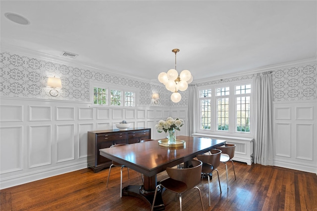 dining area featuring crown molding, dark wood-type flooring, and an inviting chandelier