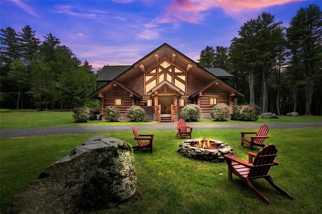 cabin with a fire pit and a lawn